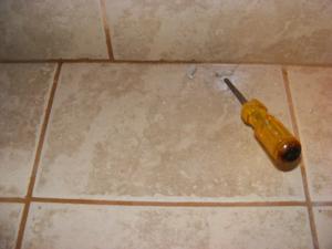 Break Through Cracked Tile with a Philip's Head Screwdriver